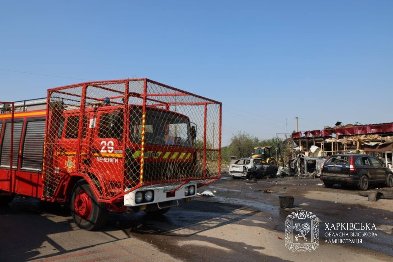 A fire engine stands beside burned vehicles and a damaged building after the missile strike in Pechenihy on 18 August 2026.